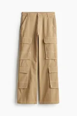 Pantalón cargo color beige de sarga de algodón con piernas amplias. Tiene cierre con botón, bolsillos al bies y bolsillos abiertos atrás. Cuenta con dos bolsillos de fuelle con solapa en cada pierna.