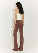 Pantalón marrón de tejido fluido con detalle drapeado en la cintura, diseño acampanado y estilo flare.
