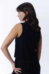 Chaleco corto negro con escote en V y cierre frontal con botones.