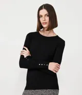 Suéter de punto color verde, con cuello barco, mangas largas y textura acanalada.