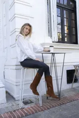 Botas texanas de caña alta color marrón, confeccionadas en cuero gamuzado, con taco de madera y puntera fina.