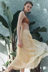 Falda midi color amarillo pálido con cintura elástica y tejido con efecto arrugado.
