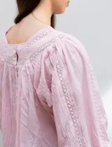 Blusa rosa claro de algodón con escote cuadrado, manga larga y bordado floral en el frente y las mangas.