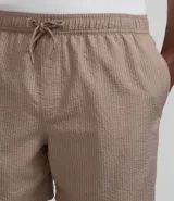 Bermuda de baño masculina confeccionada en tejido ana ruga texturizado, con lazo en la cintura, bolsillos laterales y un bolsillo trasero.