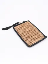 Monedero tipo sobre de paja trenzada color arena con forro negro y tira de agarre.