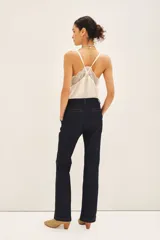 Pantalón sastrero de denim azul oscuro, corte recto, con costuras a contratono, cierre metálico, gancho sastrero y botón en la cintura.