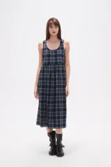 Vestido midi sin mangas confeccionado en algodón con estampado de cuadros en tonos azul y negro. Presenta un diseño holgado con cuello redondo y cierre posterior.