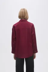Camisa color crudo de viscosa, corte holgado, con cuello camisero, cierre frontal con botones, manga larga y dos bolsillos con solapa en el pecho.