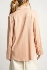 Camisa color salmón de corte oversize, confeccionada en lino y viscosa, con cuello clásico, cierre frontal con botones y mangas largas con puños anchos.