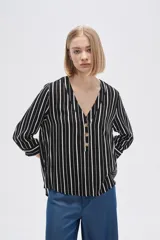 Camisa holgada de viscosa con estampado de rayas verticales en blanco y negro, cuello en V y cierre frontal con botones.