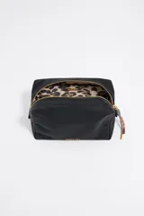 Neceser negro de nylon con logo dorado de Bimba y Lola, cierre con cremallera dorada y tirador con pieza de piel y cordón multicolor. Incluye bolsillo interior.