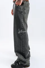 Pantalón de jean azul oscuro con efecto desgastado, corte mega baggy, bolsillos grandes y bordado lateral con el logo de la marca en color blanco.
