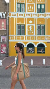 Bolso tote grande de lona color beige con asas de cuero color verde.