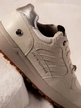 Zapatillas urbanas color beige con detalles plateados en el talón y logo de Star Wars en la lengüeta.