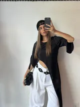 Maxiremera negra con mangas 3/4 con aberturas en los codos y corte asimétrico en el ruedo.