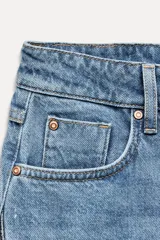 Pantalón de jean de tiro medio con cinco bolsillos, corte wide leg y detalle de tejido con lavado lateral combinado.