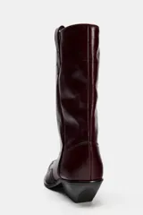 Bota de cuero color borgoña, estilo cowboy, con puntera fina y tiradores laterales.