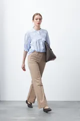 Pantalón negro de tiro alto, corte recto y silueta clásica. Presenta costuras verticales marcadas en la parte delantera de las piernas.