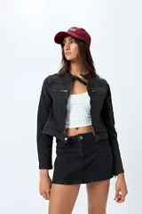 Minifalda de denim negro con diseño de paneles frontales y cierre frontal con botón y cremallera.