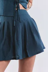Short pollera plisado con cierre trasero.