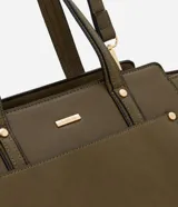 Cartera mediana color beige con paneles laterales de gamuza, doble asa de mano y correa larga desmontable.