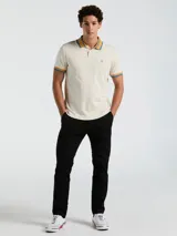 Polo manga corta color crema con cuello y puños a rayas en tonos azul y naranja.