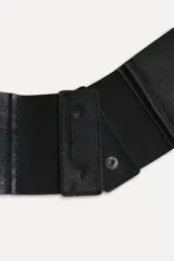 Cinturón fajín de cuero negro de 10 cm de ancho con tejido elástico combinado a tono. Cierre con botones a presión ocultos.