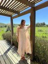 Vestido camisero amplio y largo de lino color azul, con botones de nácar, cuello camisero y bolsillos laterales.