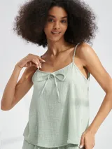 Musculosa color amarillo pálido con tirantes finos y detalle de lazo en el escote.