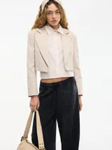 Blazer cropped color beige con solapa y camisa desmontable mediante botones. Confeccionado en algodón y elastano.