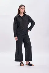 Pantalón negro con bordado calado, de corte palazzo y tiro alto.
