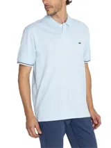 Remera polo celeste de piqué de algodón pima, con cuello clásico, tapeta de dos botones y mangas cortas con ribete azul marino. Logo de la marca bordado en el pecho.