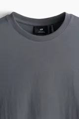 Remera gris de corte estándar, con cuello redondo ribeteado y bajo recto. Confeccionada con tejido funcional COOLMAX®, una fibra exclusiva de poliéster de secado rápido que elimina la humedad y regula la temperatura corporal.