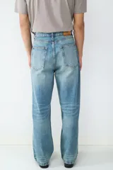 Pantalón de jean celeste de corte recto y holgado, con diseño clásico de cinco bolsillos, cierre de botón y cremallera.