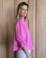 Blusa color lila claro, con cuello mao con volado y escote en V. Mangas largas con volumen y puños ajustados con elástico.