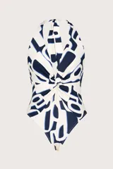 Traje de baño entero con estampado abstracto en blanco y azul marino, con escote halter y nudo central.
