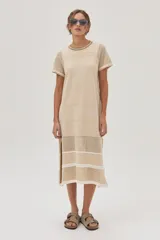 Vestido midi de tejido de punto color beige, con escote redondo, mangas cortas, tajos laterales y diseño con patrón de puntos calados y rayas.
