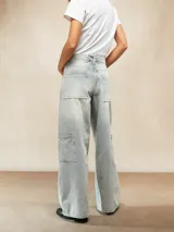 Jean ancho de tiro alto, color celeste claro desgastado, con corte holgado y bolsillos cargo en los laterales de las piernas.