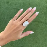 Anillo con perla barroca irregular de color blanco iridiscente, engarzada en montura de plata texturizada.