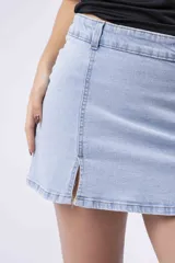 Minifalda de jean de tiro alto, color celeste claro lavado, con roturas sutiles y aberturas frontales en el ruedo.