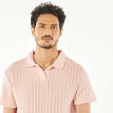 Remera color rosa de punto gofrado con cuello polo y mangas cortas.