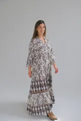 Vestido largo con estampado geométrico en blanco y negro, con mangas 3/4 y cuello en V.