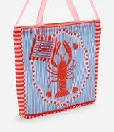 Bolso tipo shopper plegable de poliéster, con fondo a rayas verticales azules y blancas, y bordes rojos a rayas. Presenta un estampado central de una langosta roja dentro de un marco decorativo con corazones rosados.