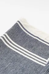 Lona de playa rectangular con diseño estampado a rayas rojas y blancas.