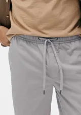 Bermuda color beige de sarga con cintura elastizada y cordón ajustable.