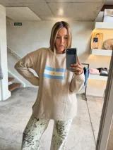 Sweater azul marino de tejido grueso, corte oversize y hombros caídos, con un bordado frontal que representa la bandera de Argentina.