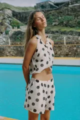 Bermuda blanca con estampado de lunares negros, de tiro medio con pinzas y bolsillos frontales.