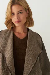 Tapado marrón de largo medio, abierto, con cuello y envivado. Hecho 100% en Uruguay con tela 100% lana fina sin teñir, diseñada exclusivamente por Don Baez.