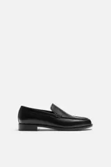 Mocasín de cuero negro con suela a tono y ligero tacón.