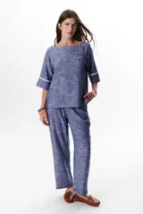 Blusa azul de lino con escote barco y mangas 3/4 con detalle de ribete blanco.